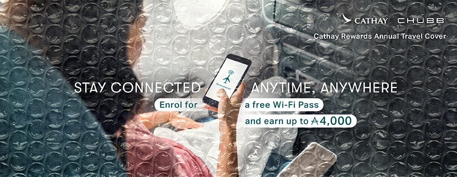 A woman holding her phone enjoying inflight Wi-Fi. Stay connected, anytime, anywhere. Enrol in Cathay Rewards Annual Travel Cover for a free Wi-Fi pass and earn up to 4,000 Asia Miles.